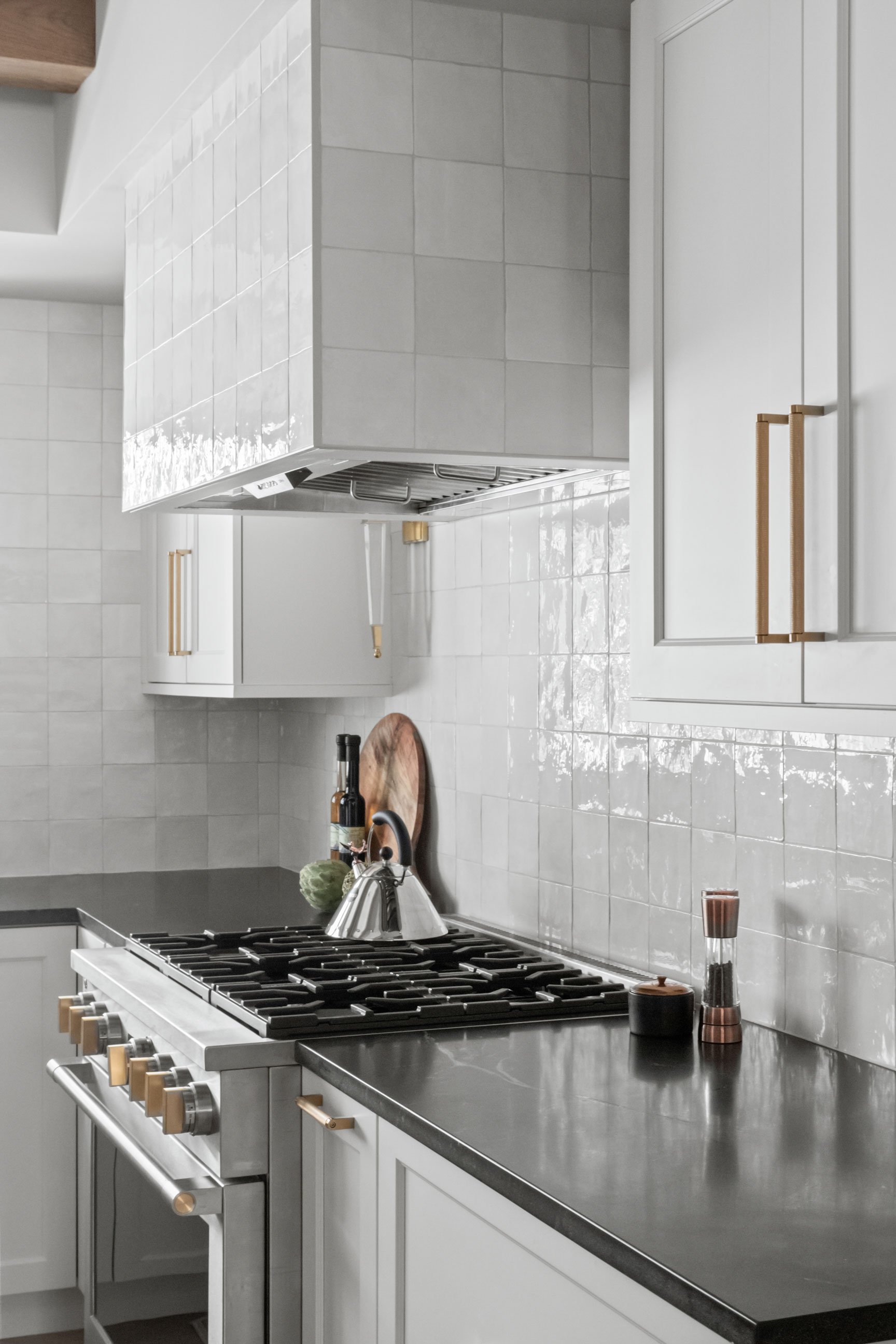 Nero Mist Honed granite countertops on perimeter, Flash Series Arizona Tile on full-height backsplash and hood