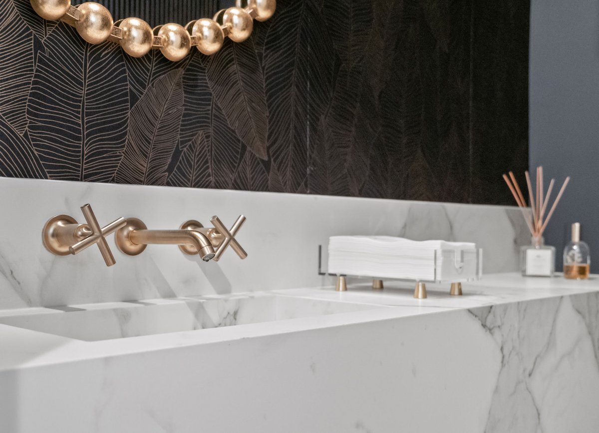 Porcelain top with integrated sink, wallpaper, and reeded wall (seen in mirror)