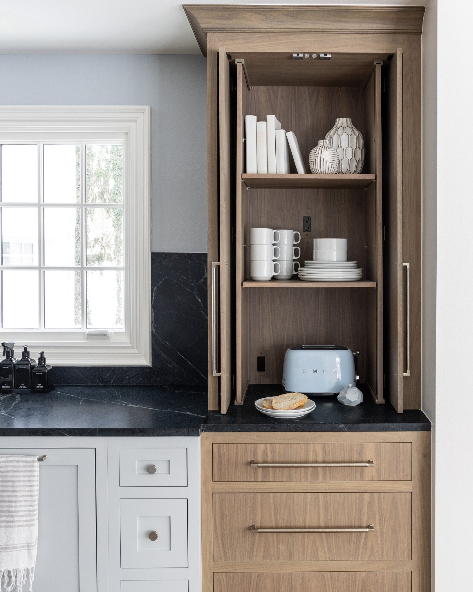 Grain-matched walnut towers flank the kitchen sink