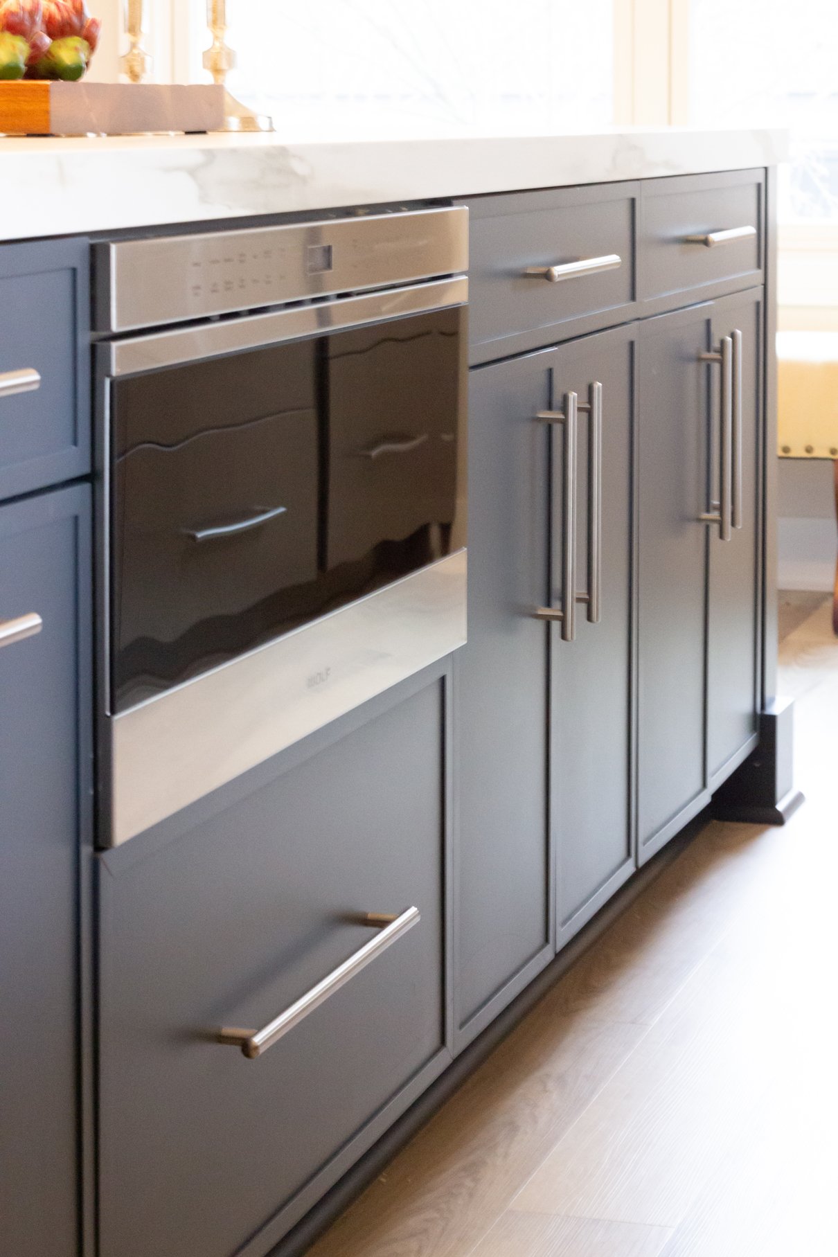 Island features thin shaker cabinetry in a rich blue