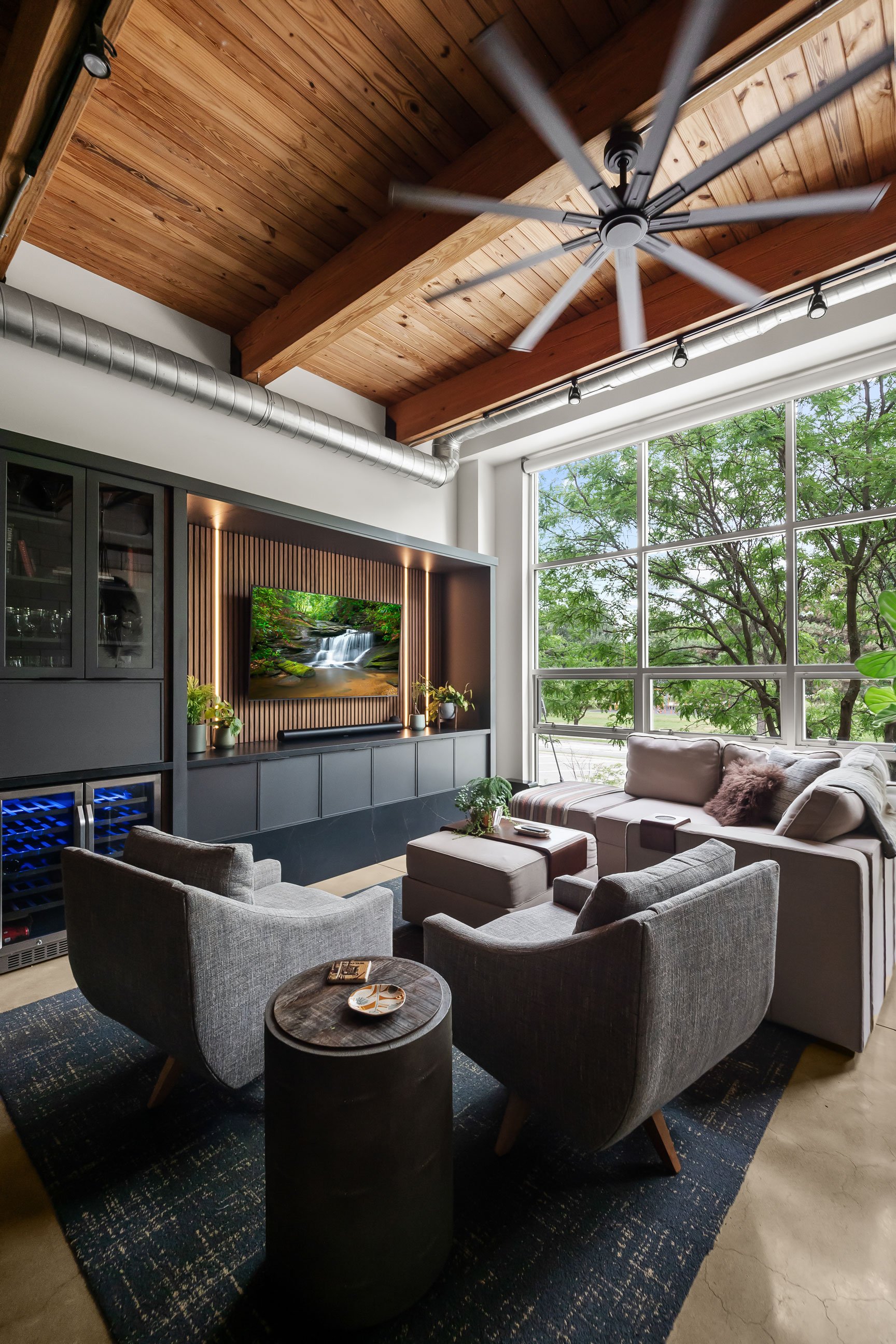 Contemporary loft entertainment area featuring natural walnut and black-painted Inspira Cabinetry