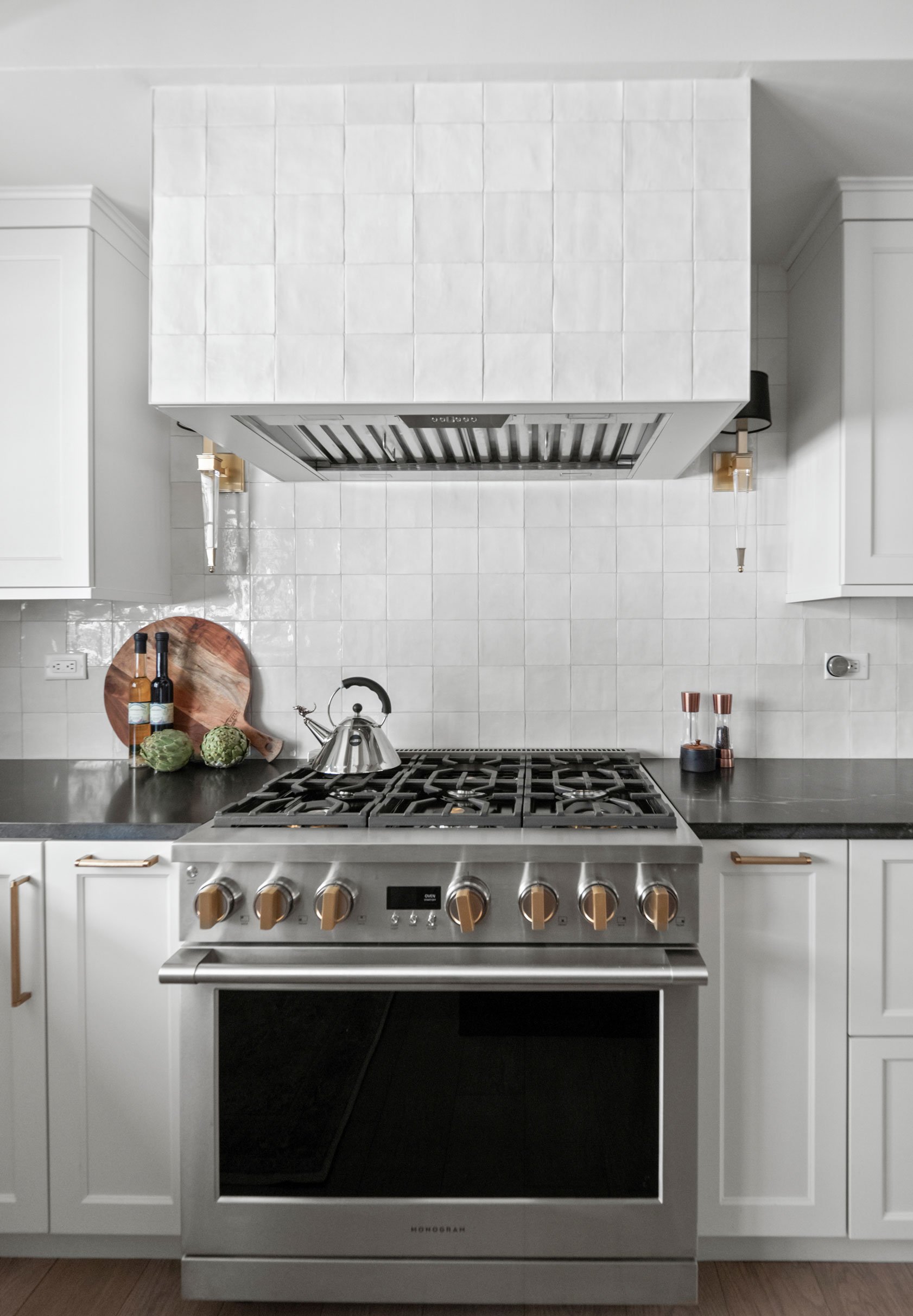 Nero Mist Honed granite countertops on perimeter, Flash Series Arizona Tile on full-height backsplash and hood