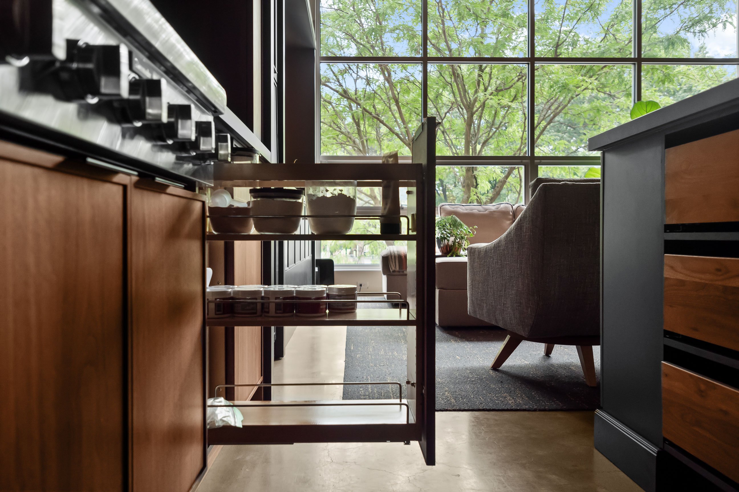 Contemporary loft kitchen featuring natural walnut and black-painted Inspira Cabinetry - spice pullout detail